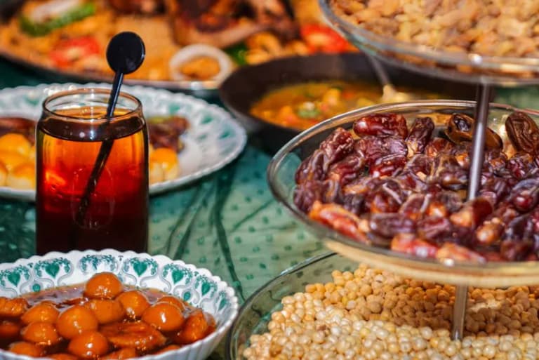 A vibrant Iftar table spread with dates, sweets, and juices