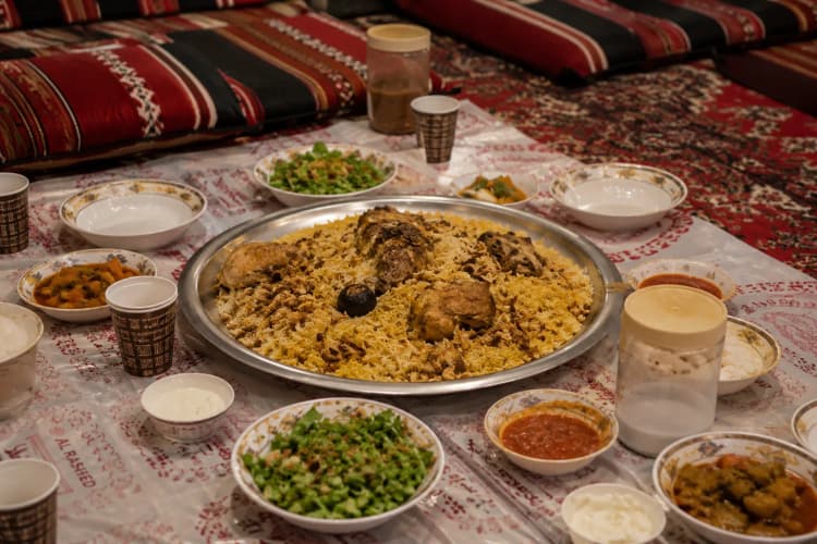Traditional Saudi kabsa served on a large communal platter on the floor